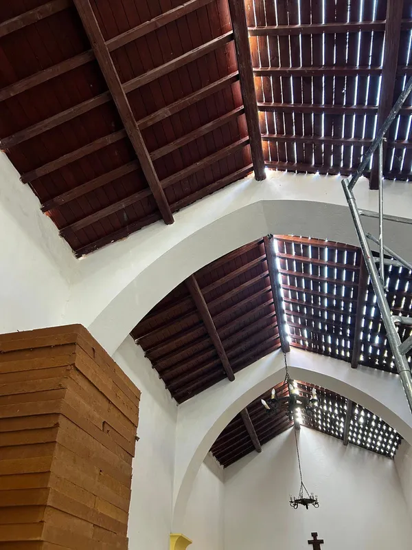 La copertura in legno vista dall'interno della chiesa durante il cantiere