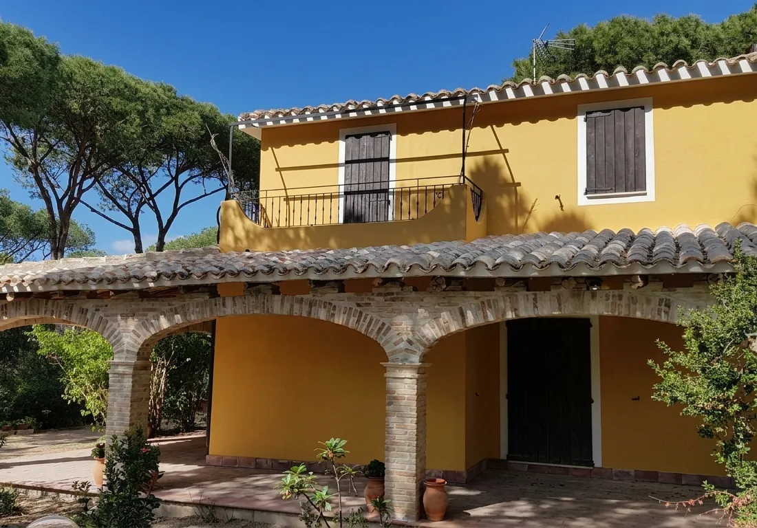 Front of the villa with veranda and arches, daytime view
