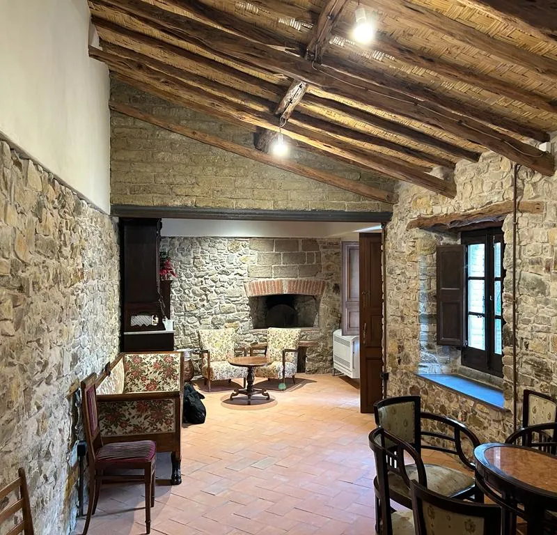 Interior of the restored Campidano house in Sanluri, with exposed stone, juniper beams and Sardinian terracotta